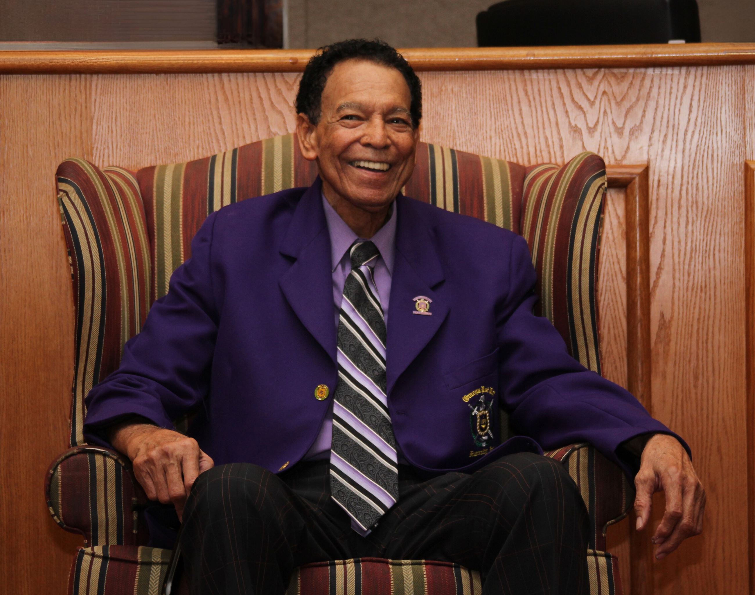 Dick Blake smiling while sitting in chair